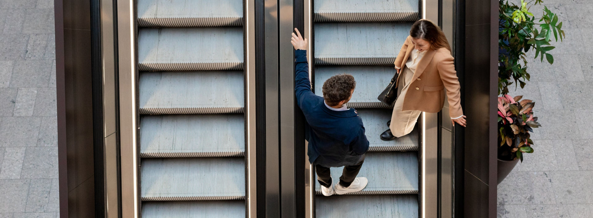 Man och kvinna på KONE rulltrappa i Via Vika i Oslo.